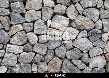 La texture de fond de mur de pierre de granit rugueux gris Banque D'Images