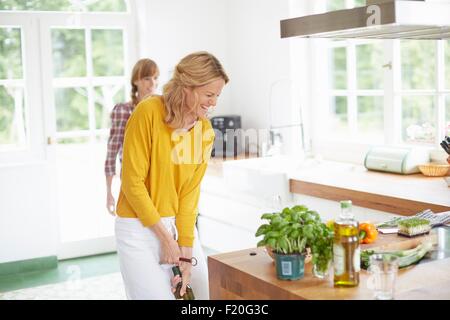 Bouteille de vin en ouverture femme cuisine Banque D'Images