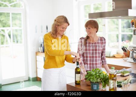 Bouteille de vin en ouverture femme cuisine Banque D'Images