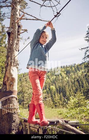 Jeune fille marchant sur le pont de corde unique Banque D'Images