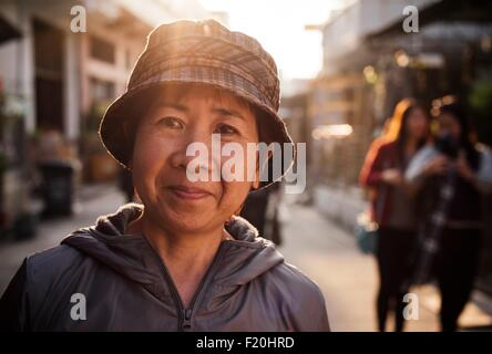 Portrait of senior woman wearing bucket hat, smiling at camera Banque D'Images