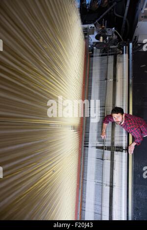 Portrait de jeune homme frais généraux weaver et vieille machine à tisser dans l'usine de textile Banque D'Images