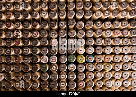 Rangées de bobines dentelle sur de vieilles machines à tisser dans l'usine de textile Banque D'Images