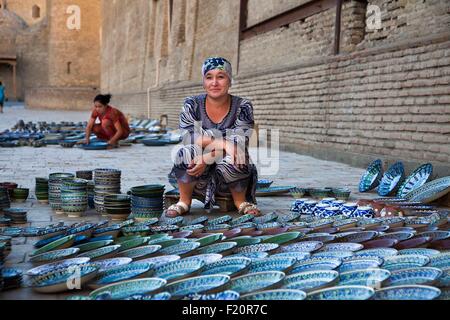L'Ouzbékistan, Boukhara, inscrite au Patrimoine Mondial de l'UNESCO, une dame traditionnelle de vente de poterie ouzbek Banque D'Images