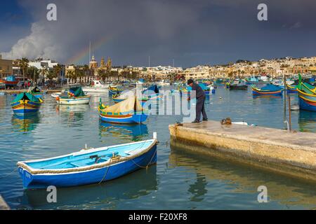 Malte, Marsaxlokk, paysage marin d'un pêcheur d'essayer d'amarrer son bateau dans un village méditerranéen traditionnel maltais et bateaux Banque D'Images