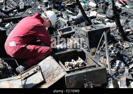 Les services essentiels, le feu, l'examen de l'équipe de médecine légale de ruine carbonisée pour risque d'incendie. Banque D'Images