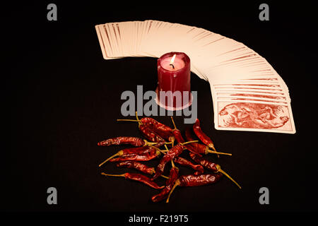 Dans l'illustré d'un paquet de cartes éventail ouvert , une bougie rouge et le poivron rouge sèche. Banque D'Images