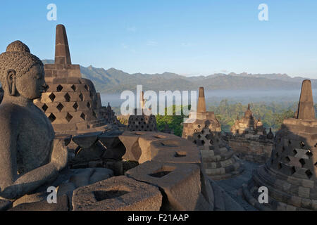 L'Indonésie, de Java, Borobudur, Bouddha assis et de petits stupas au niveau supérieur Banque D'Images