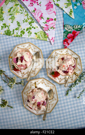 Eton Mess, un dessert traditionnel anglais fait avec de la meringue, crème, fraises et ici servi dans trois tasses en porcelaine a UK. Banque D'Images