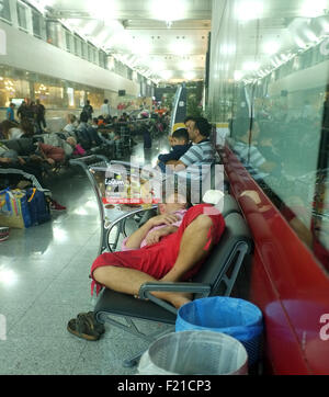 Les passagers fatigués dormir à l'aéroport. Banque D'Images