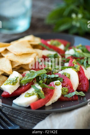 Heirloom tomatoes frais dans une salade caprese au pesto Banque D'Images