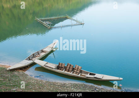 Bateaux en bois mince amarré dans les eaux peu profondes d'un petit lac en Shichuon village, près de la montagne Huangshan, Anhui Province jaune Banque D'Images