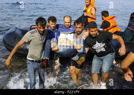 Lesbos, Grèce. 09Th Nov, 2015. Les réfugiés munis de leur compagnon blessé du bateau à la rive de Lesbos. Des centaines de réfugiés, principalement en provenance de Syrie, l'Irak et l'Afghanistan sont encore à venir à l'île grecque de Lesbos sur une base quotidienne, après avoir fait le périlleux voyage de la côte turque en petits bateaux gonflables. Crédit : Michael Debets/Pacific Press/Alamy Live News Banque D'Images