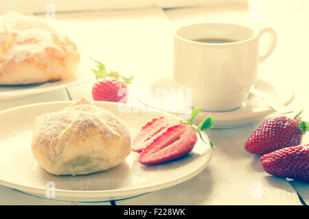 Fraise moelleux avec café et pâtisserie fraise entière sur une vieille table en bois. Banque D'Images