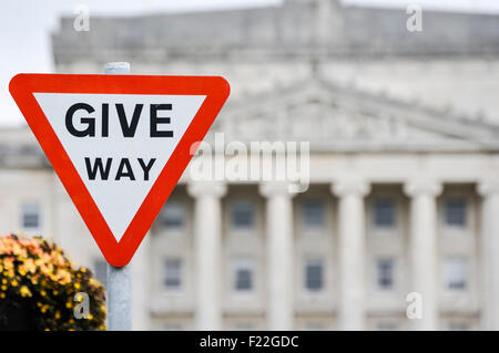 Céder le passage de circulation routière affiche à l'extérieur des édifices du Parlement Stormont Estate symbolisant la négociation et le compromis entre les partis politiques. Banque D'Images