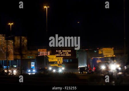 Les automobilistes sur l'I-10 à Phoenix passent des panneaux lumineux avertissant d'un tireur de l'I-10 et affichant une ligne de pointe de police pour information. Banque D'Images