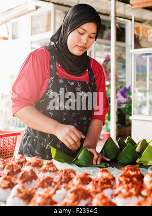 Une femme musulmane faisant Nasi lemak. Georgetown, Penang, Malaisie Banque D'Images