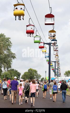 Des foules de gens marche sous un télésiège colorés ride à la Minnesota State Fair. Banque D'Images