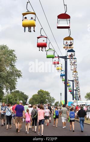 Des foules de gens marche sous un télésiège colorés ride à la Minnesota State Fair. Banque D'Images