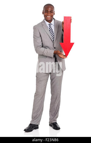 Portrait d'afro American businessman holding flèche rouge pointant vers le bas sur fond blanc Banque D'Images