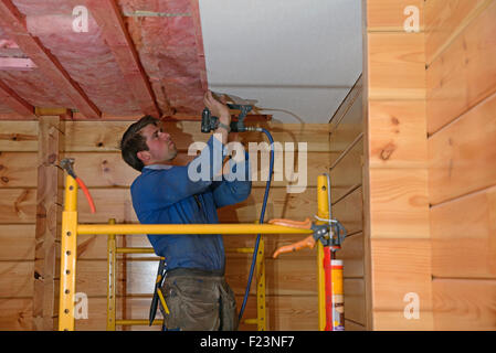 Un constructeur agrafe jusqu'carreaux de plafond dans le plafond d'un bâtiment de style lockwood Banque D'Images