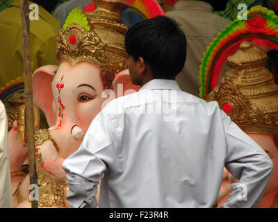 Un Indien a l'air à l'occasion d'un grand Ganesh idoles pour vente avant Ganapati festival à l'Inde. Banque D'Images