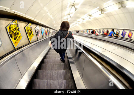 Londres, Angleterre, Royaume-Uni. La station de métro de Londres - femme sur un escalator going down Banque D'Images