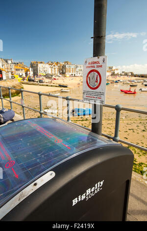 Un gros ventre corbeille solaire sur la promenade de St Ives, Cornwall, UK. Le solar powered bin, compacte les déchets aussi il a besoin Banque D'Images