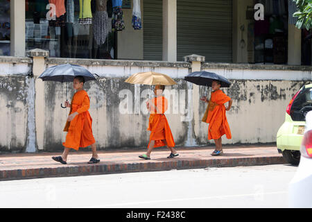 Les garçons novice moines bouddhistes à pied le long de parapluies Banque D'Images