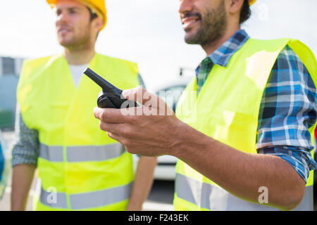 Close up of builders en vestes avec talkie walkie Banque D'Images