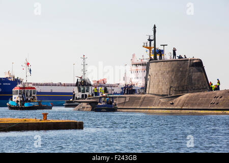 L'art de la classe Astute hunter killer un sous-marin nucléaire est déplacé de BAE Systems dans la région de Barrow in Furness jusqu'à la base de sous-marins de Faslane, en Écosse, au Royaume-Uni. Les sous-marins sont armés de torpilles Spearfish et missiles de croisière Tomahawk. Cette photo montre le héron du Pacifique un navire de transport nucléaire derrière. Banque D'Images