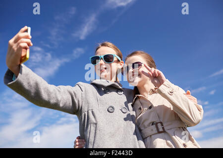 Les filles heureuse avec le smartphone en tenant l'extérieur selfies Banque D'Images