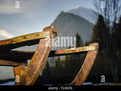 Old vintage traîneau en bois avec la montagne en arrière-plan. Tôt le matin, par le lever du soleil. Banque D'Images