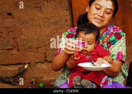 Guatemala, San Bartolo, mère de donner des aliments complémentaires à l'enfant (chispitas Osber danilo sontay Ramirez 11 mois, Candelaria Sandiega Ramirez Ramires 23 ans) Banque D'Images