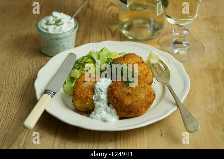 Fishcakes épicé avec le chou et la sauce tartare. Un repas de fruits de mer propose une cuisine britannique de la farine de poisson plat repas petite assiette manger manger Banque D'Images