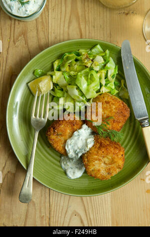 Fishcakes épicé avec le chou et la sauce tartare. Un repas de fruits de mer propose une cuisine britannique de la farine de poisson plat repas petite assiette manger manger Banque D'Images