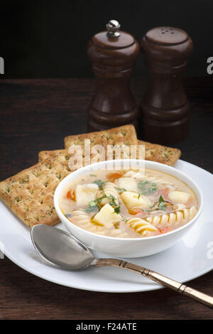 La pomme de terre, poulet et pâtes soupe avec des craquelins Banque D'Images