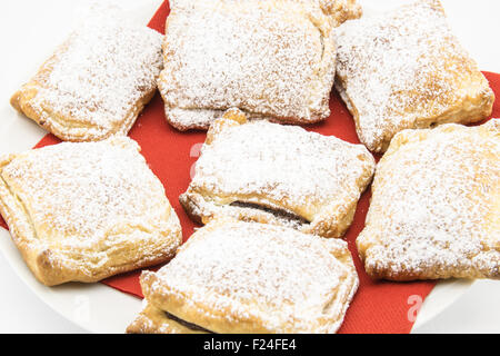 Des biscuits faits à la main de pâte feuilletée farcie de chocolat et recouvert de sucre en poudre Banque D'Images