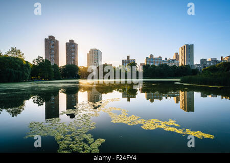Le lever du soleil sur les bâtiments et la Harlem Meer, à Manhattan, New York. Banque D'Images