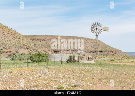 17 Dysart Road, AFRIQUE DU SUD - le 11 août 2015 : un moulin de pompage d'eau et barrage avec le Quiver Tree Forest à la gauche. Banque D'Images