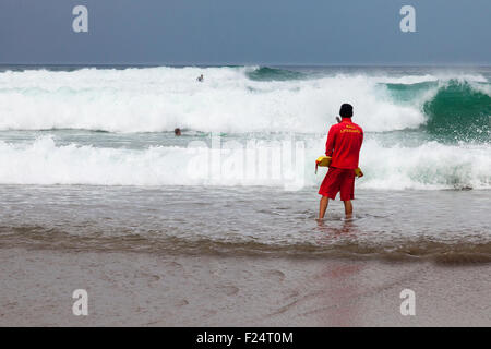 Trebarwith Strand, Cornwall, Angleterre, Royaume-Uni 11 septembre 2015. Un sauveteur RNLI regarder les surfeurs sous un ciel gris sur un jour nuageux au nord des Cornouailles Trebarwith Strand sur la côte de l'Atlantique. Credit : Mark Richardson/Alamy Live News Banque D'Images