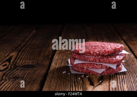 Faites un peu de viande hachée crue (hamburgers) sur une vieille table en bois Banque D'Images