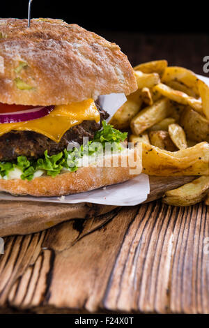 Burger Ciabatta avec des frites sur fond rustique Banque D'Images