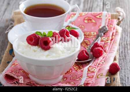 Pouding au riz et aux framboises et thé pour le petit déjeuner Banque D'Images