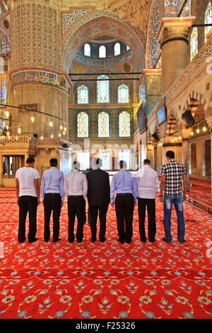 Les jeunes hommes priant dans la mosquée bleue, Istanbul Banque D'Images