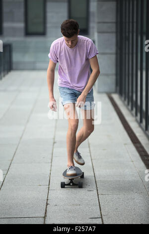 Adolescent élégant équitation un longboard Banque D'Images