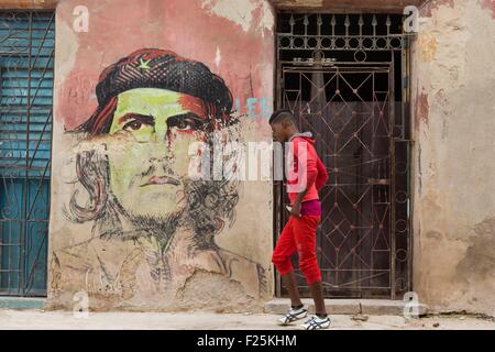 Cuba, Ciudad de la Habana Province, La Havane La Habana Vieja, quartier classé au Patrimoine Mondial de l'UNESCO, l'homme marchant par une murale représentant Che Guevara (Copyright Alberto Diaz Guttierez alias Korda) Banque D'Images