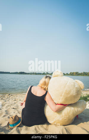 Portrait d'une jeune et belle femme avec un gros nounours. Banque D'Images