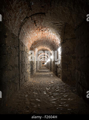 Vieille brique médiévale tunnel avec la lumière au bout Banque D'Images