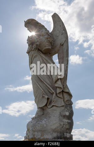 Angel pierre tombale memorial à St George's churchyard, Portland Bill Dorset UK avec le soleil qui brille derrière elle. Banque D'Images
